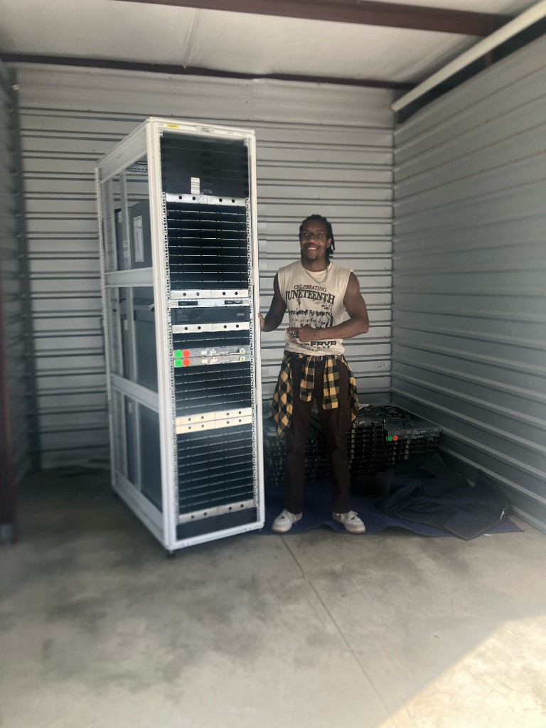 A student standing beside a server rack for the AARI community cloud